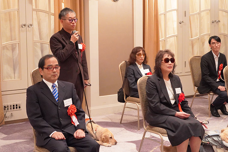 板嶌憲次郎さんと盲導犬テスの写真